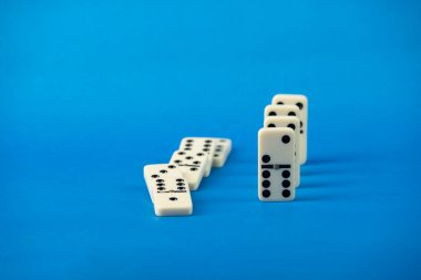 Mavi arka planda duran domino taşları. Beyaz Kemik Tahta Oyunu.