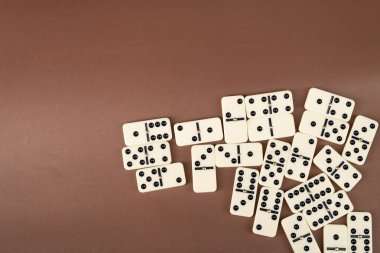 Dominoes with brown background, copy space and various angles, board games concept clipart
