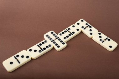 Dominoes on a brown background. White Bones Board Game. clipart