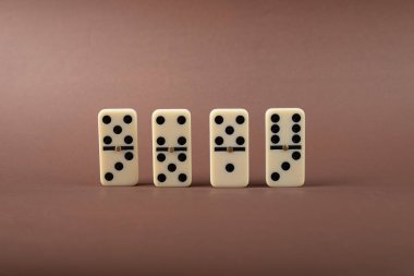 Dominoes standing on a brown background. White Bones Board Game. clipart