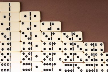 Dominoes on a brown background. White Bones Board Game. clipart