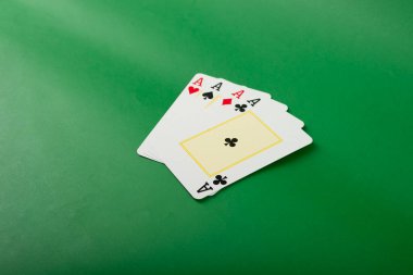 Playing card for poker and gambling, four aces. Isolated on green background. clipart