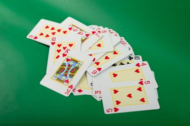 Poker ve kumar kartları, yeşil arka planda izole edilmiş..