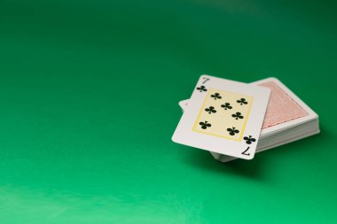 Playing cards for poker and gambling, isolated on green background. clipart