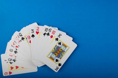 Playing cards for poker and gambling, isolated on blue background. clipart