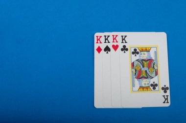 Playing card for poker and gambling, four kings. Isolated on blue background. clipart