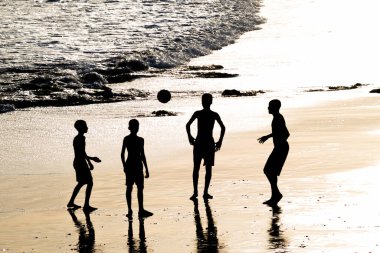 Salvador, Bahia, Brezilya - 14 Şubat 2019: Genç insanlar, siluet içinde öğleden sonra Salvador, Bahia 'da plaj futbolu oynarken görüldü..