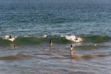 Salvador, Bahia, Brezilya - 17 Mart 2019: İnsanlar ve turistler denizde banyo yapıyor ve Bahia 'nın Salvaldor kentindeki Farol da Barra plajında eğleniyorlar.