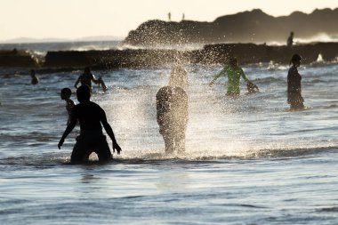 Salvador, Bahia, Brezilya - 17 Mart 2019: İnsanlar Salvador, Bahia 'daki Farol da Barra plajında güçlü güneş altında eğlenirken görülüyor.