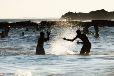 Salvador, Bahia, Brezilya - 17 Mart 2019: İnsanlar ve turistler Salvador, Bahia 'daki Farol da Barra plajında banyo yaparken eğleniyorlar.