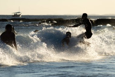 Salvador, Bahia, Brezilya - 17 Mart 2019: Turistler Salvador, Bahia 'daki Farol da Barra plajında denize girerken iyi eğlenceler.
