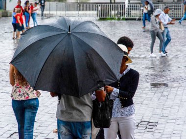 Salvador, Bahia, Brezilya - 19 Temmuz 2019: Yoldan geçenler Salvador, Bahia 'nın tarihi merkezinde sağanak yağış sırasında görüldü.