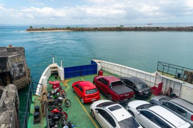 Vera Cruz, Bahia, Brazil - January 24, 2023: View of vehicles boarded on a Ferry Boat that is leaving the Bom Despacho maritime terminal in the city of Vera Cruz in Bahia. clipart