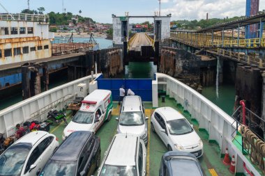 Vera Cruz, Bahia, Brazil - January 24, 2023: View of vehicles boarded on a Ferry Boat that is leaving the Bom Despacho maritime terminal in the city of Vera Cruz in Bahia. clipart