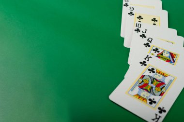 Salvador, Bahia, Brazil - May 10, 2024: Playing cards isolated on green background. Gambling. clipart