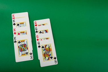 Salvador, Bahia, Brazil - May 10, 2024: Playing cards isolated on green background. Gambling. clipart