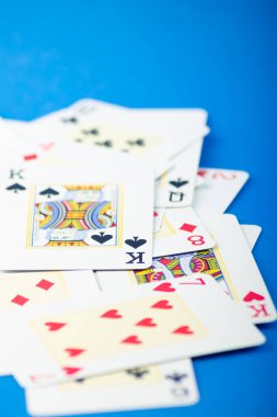 Salvador, Bahia, Brazil - May 10, 2024: Playing cards isolated on blue background. Gambling. clipart