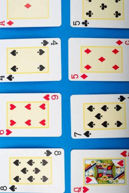 Salvador, Bahia, Brazil - May 10, 2024: Playing cards isolated on blue background. Gambling. clipart