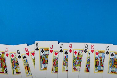 Salvador, Bahia, Brezilya - 10 Mayıs 2024: Poker ve kumar kartları, mavi arka planda izole edilmiş.