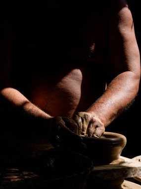 Seramik tencereyi şekillendiren bir zanaatkarın ellerine yakın çekim. Kil sanatı