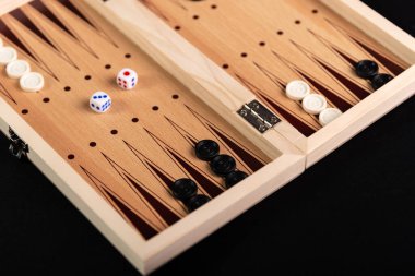 Geleneksel tavla oyunu. Siyah arkaplanda tavla oyunu parçaları olan tahta.