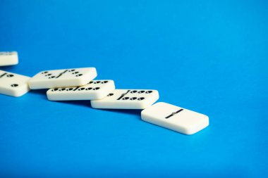 Mavi arka planı olan dominolar, kopyalama alanı ve çeşitli açılar. Beyaz Kemik Tahta Oyunu.