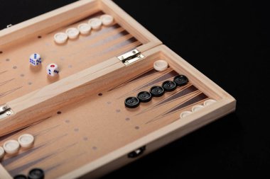 Geleneksel tavla oyunu. Siyah arkaplanda tavla oyunu parçaları olan tahta.