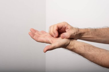 Elini kaşıyan orta yaşlı bir adam. Deri hastalığı. Alerjik reaksiyon. Dermatolojik bakım