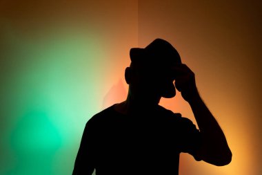 Silüet şapkalı bir adamın stüdyo portresi. Renkli arkaplanda izole.