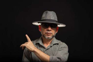 Siyah arka planda gri şapkalı, gözlüklü sakallı adam. Fotoğraf stüdyosunda..