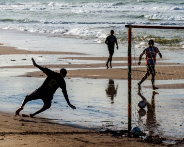 Salvador, Bahia, Brezilya - 16 Haziran 2019: Kimliği belirsiz insanlar, siluette, Salvador, Bahia 'da plajda futbol oynarken görüldü..