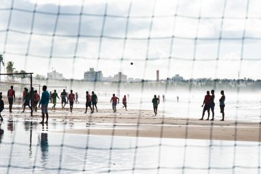 Salvador, Bahia, Brezilya - 16 Haziran 2019: Erkekler, Bahia 'nın Salvador kentindeki bir plajda plaj futbolu oynarken görülüyor.