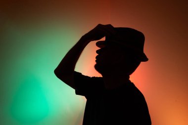 Silüet şapkalı bir adamın stüdyo portresi. Renkli arkaplanda izole.