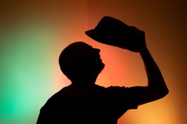 Silüet şapkalı bir adamın stüdyo portresi. Renkli arkaplanda izole.