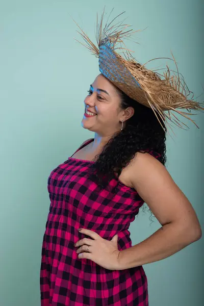 stock image Woman dressed in red checkered clothing for the Sao Joao festival posing for a photo. Braided hair and cheerful. Isolated on light background.