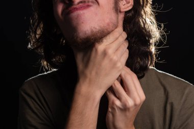 Adam eliyle boynunu kaşıyordu. Deri hastalığı. Kızarıklık, alerji. Siyah arkaplanda izole.