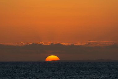 Renkli bulutlarla güzel dramatik ve rahatlatıcı sarı ve turuncu gün batımı. Doğayı yaşa.