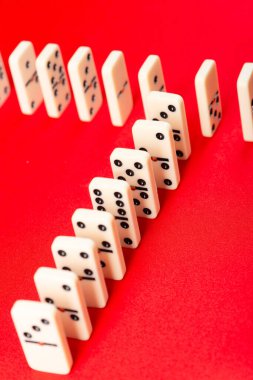 Domino etkisi başlamaya hazır. Arka arkaya akrilik parçalar. Kırmızı arkaplanda izole.