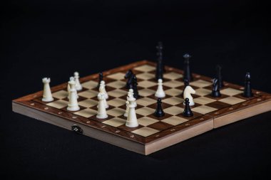 Aydınlık ve karanlık parçalı satranç tahtası. Oyun konsepti. Masa oyunu. Hobi olarak. Siyah arkaplanda bir oyun için oyun alanında satranç.