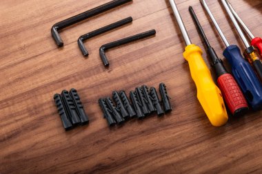 Pense, tornavida, ingiliz anahtarı ve ahşap arka planda izole edilmiş diğer aletler.