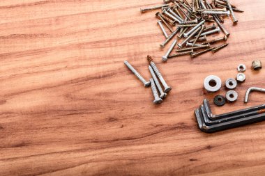 Vidalar, fındıklar, çamaşır makineleri, İngiliz anahtarı, ahşap arka planda izole edilmiş..