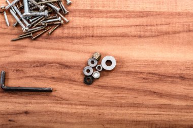 Vidalar, fındıklar, çamaşır makineleri, İngiliz anahtarı, ahşap arka planda izole edilmiş..