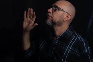 Siyah arka planda izole edilmiş, reçeteli gözlüklü kel adamın portresi..