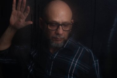 Siyah arka planda izole edilmiş, reçeteli gözlüklü kel adamın portresi..