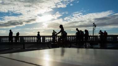 Salvador, Bahia, Brezilya - 02 Ağustos 2019: Salvador, Bahia 'daki Porto da Barra plajında yürüyen ve günbatımının keyfini çıkaran insanların silueti.