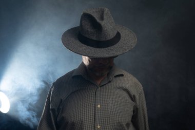 Sakallı, güneş gözlüklü ve fotoğraf için poz veren bir adamın portresi. Dumanlı arkaplana karşı.