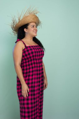 Woman dressed in red checkered clothing for the Sao Joao festival posing for a photo. Braided hair and cheerful. Isolated on light background. clipart