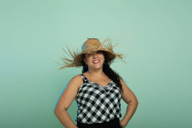 Sao Joao Festivali 'nde hasır şapkalı, mutlu ve gülümseyen bir kadın. Açık yeşil arkaplanda izole.