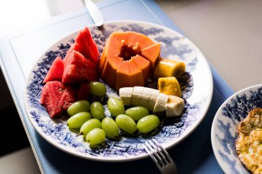 Tabakta kızarmış yumurta papaya karpuz üzümü ve muz ile sabah yemeği. Sağlıklı beslenme. Meyve ve protein.