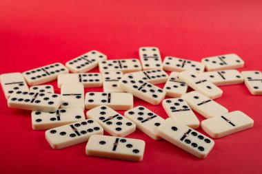 Kırmızı arka planı olan dominolar, kopyalama alanı ve çeşitli açılar. Beyaz Kemik Tahta Oyunu.